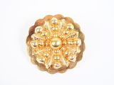 une image représentant une broche en or ornée de perles sur fond blanc