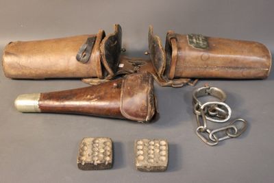 an old pair of leather holsters and a pair of metal studs