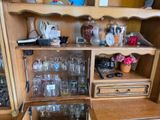 a wooden cabinet with a bunch of wine glasses on top of it