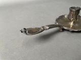 a silver plate with a spoon on it on a table