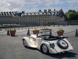 a small white car parked in front of a large building