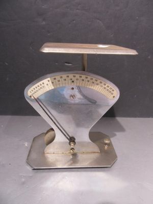 une balance métallique sur laquelle est posée une horloge, posée sur une table