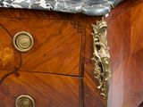 a marble top on a wooden chest of drawers