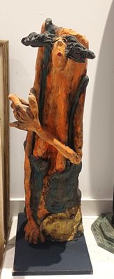 une sculpture représentant un homme tenant un bâton, posée sur une table