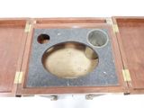 a wooden table with a marble top and a metal bowl on it