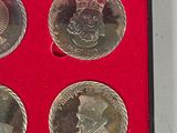 three silver coins in a red box on a white surface