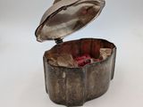 a small silver box with a lid on a white surface