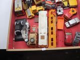 de nombreuses petites voitures et camions dans une boîte posée sur une table