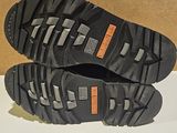 pair of black hiking shoes on a white surface with a cardboard box in the background