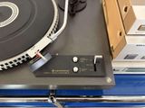 a turntable sitting on top of a table next to a box of boxes