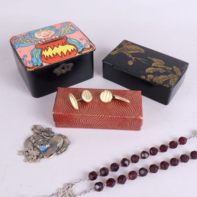 trois petites boîtes et un chapelet sont posés sur une table