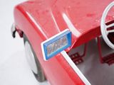 a red toy car with a steering wheel and dashboard