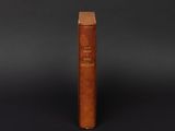 an old book with a wooden cover sitting on a black surface