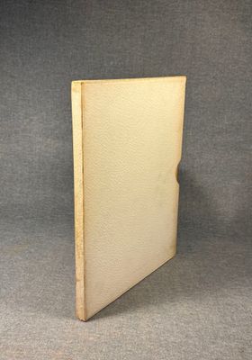 an old book sitting on top of a table next to a gray background