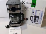 an electric coffee maker sitting on a table next to a box