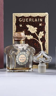 a bottle of perfume sitting next to a box of perfumes