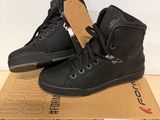 a pair of black shoes on top of a cardboard box