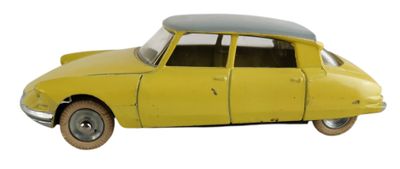 une petite voiture jaune posée sur une surface blanche, à côté d'un mur blanc