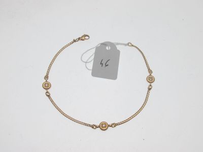 un bracelet en or avec trois petits diamants sur une chaîne