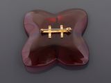a red butterfly shaped object with a gold cross on it