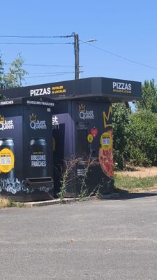 un petit bâtiment couvert de graffitis, au bord de la route