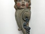 an image of a wooden sculpture of a child ' s face on a wall