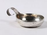 a small silver bowl with a handle on a white surface