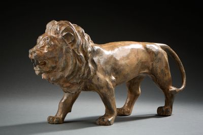 bronze statue of a lion on a gray background