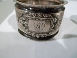 un bol en argent orné d'un monogramme, posé sur une table