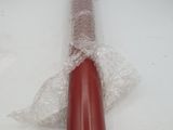 un tuyau rouge enveloppé dans du plastique, posé sur une table