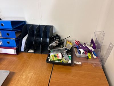 a desk with a laptop and a bunch of office supplies on it