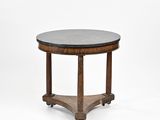 une table ronde avec un plateau en marbre noir et des pieds en bois