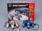 two nintendo 64 game controllers sitting next to each other on a table