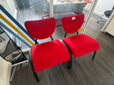 deux chaises rouges placées l'une à côté de l'autre dans une pièce