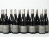 six bouteilles de vin sont alignées sur une table