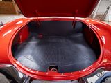 a red car with its trunk open in a garage