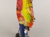 glass figurine of a colorful bird on a black base