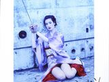 photograph of a woman sitting on the ground with a radio in her hand