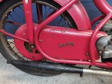 a red motorcycle parked in front of a blue wall