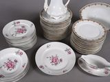 a lot of plates and cups and a pitcher on the table