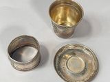 a silver cup and saucer sitting next to each other on a table