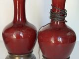 deux vases rouges posés l'un à côté de l'autre sur une table