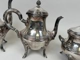 three silver teapots sitting next to each other on a table
