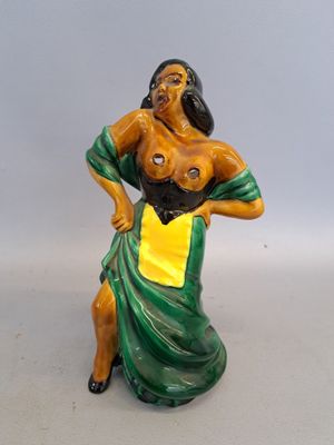 figurine représentant une femme vêtue d'une robe verte et jaune, les mains sur les hanches
