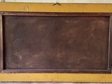 an old picture frame sitting on the floor in front of a wall