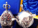 two silver teapots sitting on top of a table