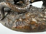 a bronze statue of a man sitting on a rock