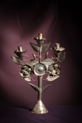 a metal candelab with a bunch of flowers on it