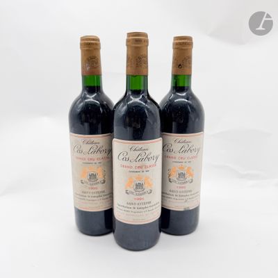 trois bouteilles de vin rouge posées sur une table blanche