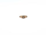 a gold ring with a diamond in it on a white surface